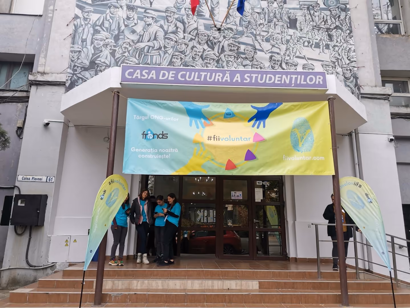 Intrarea Casei de Cultură a Studenților din București, cu bannerul #fiivoluntar al târgului de ONG-uri și voluntari în fața ușii