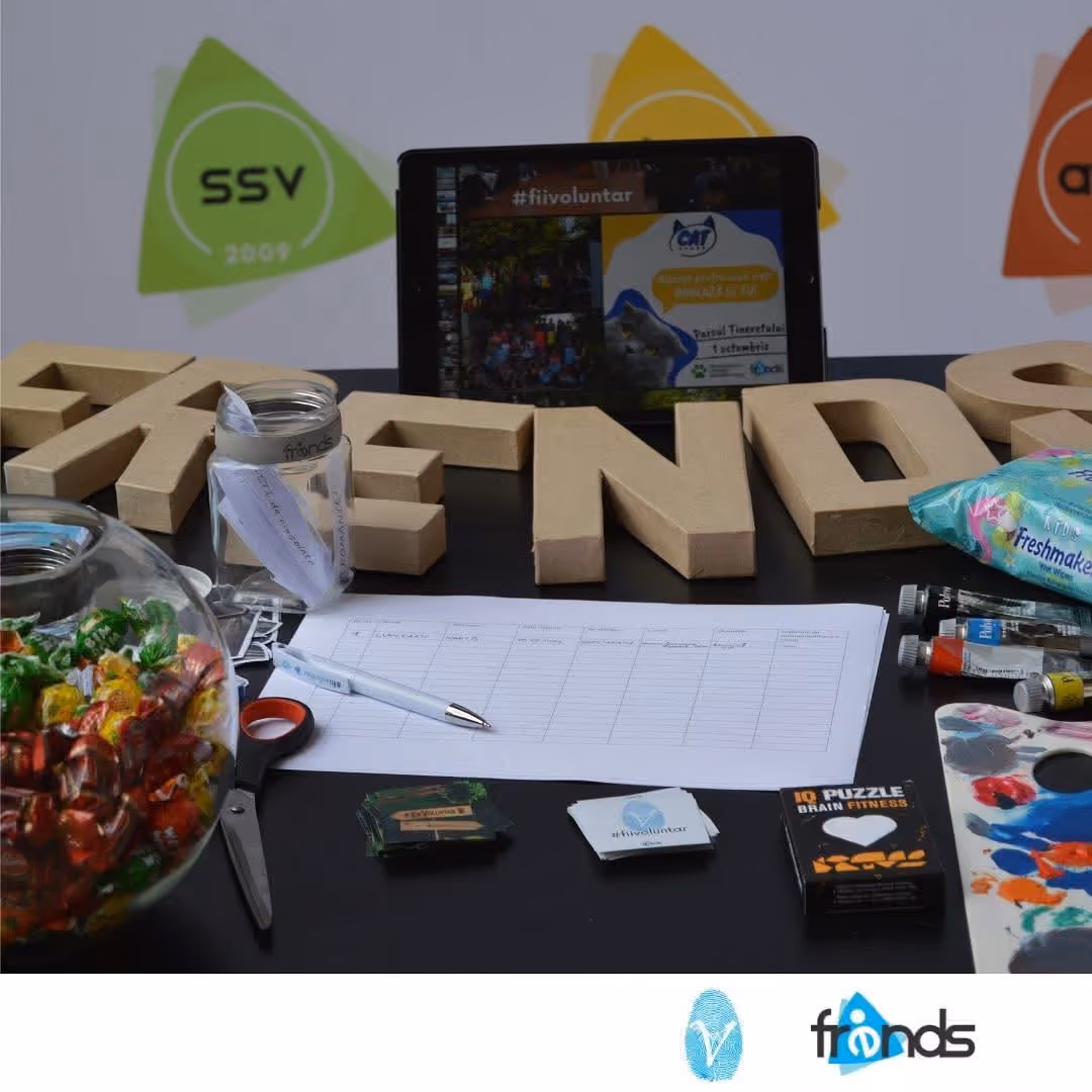 Standul FRENDS, cu literele FRENDS din carton, o tabletă cu #fiivoluntar, bomboane și o listă de înscriere
