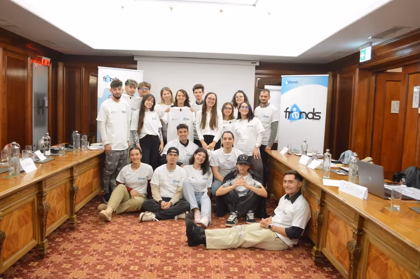 Echipa unui bootcamp START adunată în fața bannerului FRENDS
