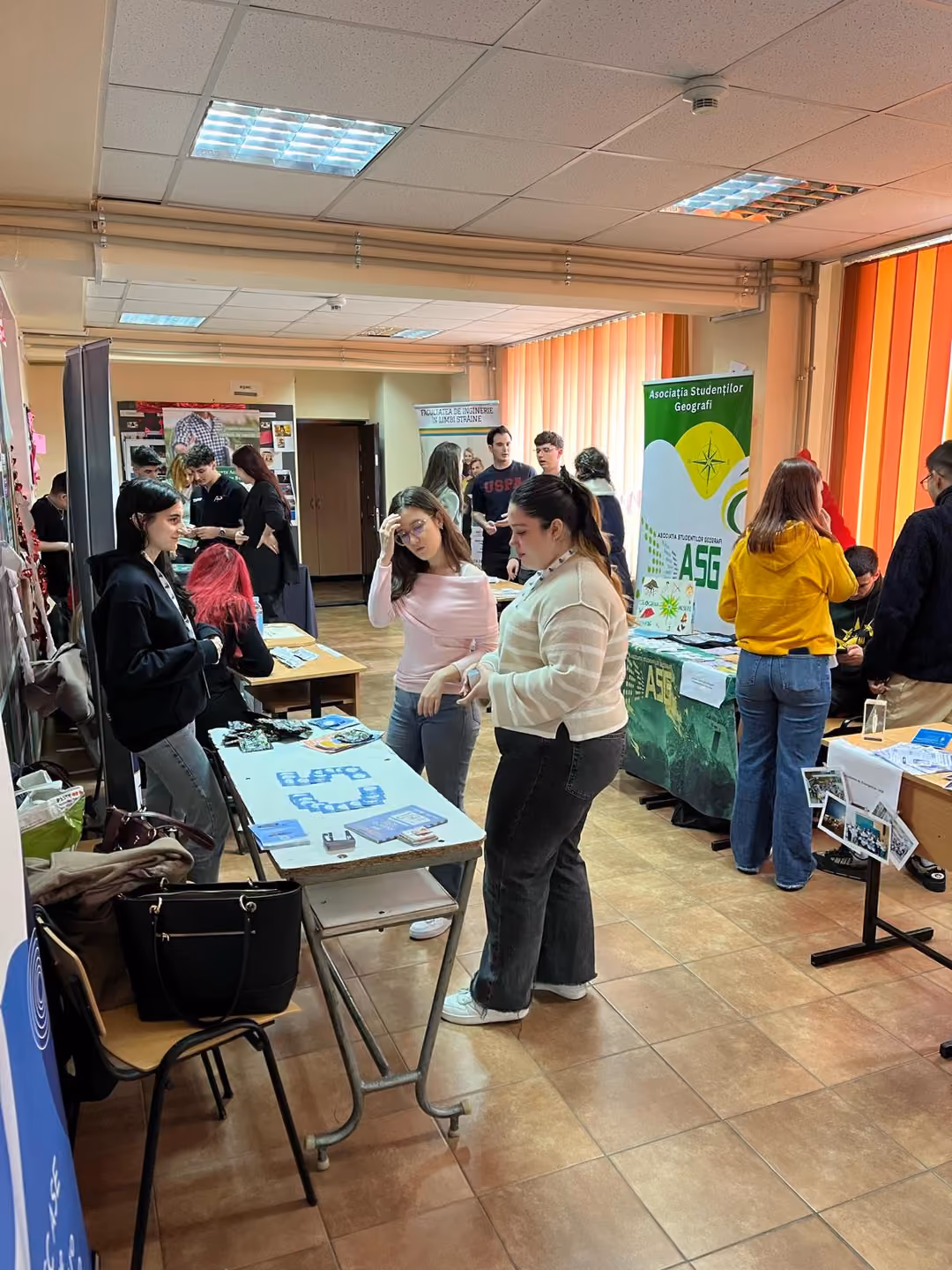 Elevi discutând cu studenții la standurile asociațiilor studențești
