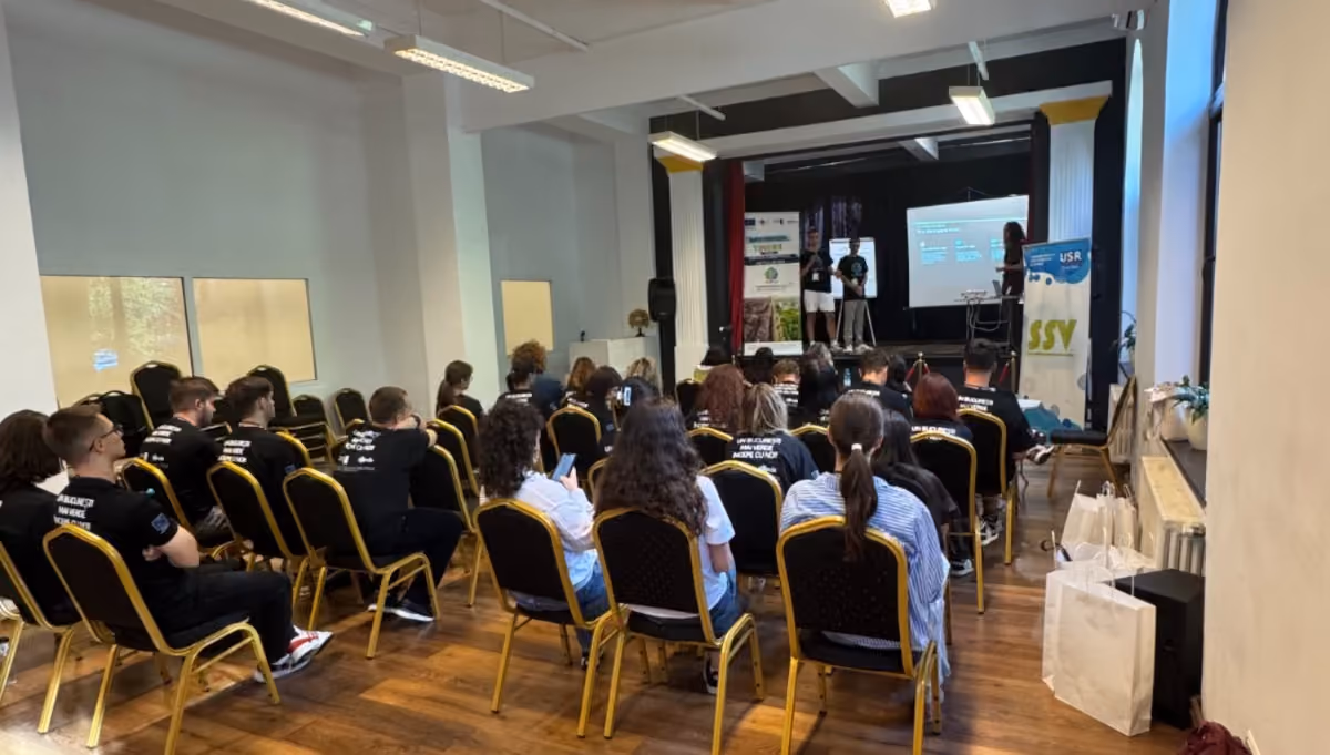 Participanți urmărind prezentarea finală a unei echipe în fața juriului