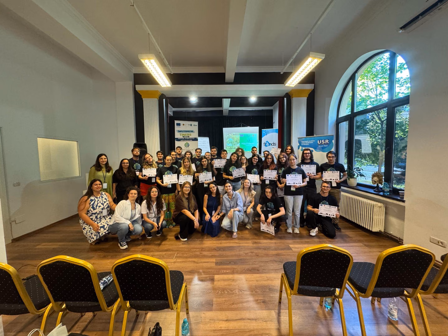 Participanții, mentorii și organizatorii Youth4Air cu diplomele primite, în sala evenimentului